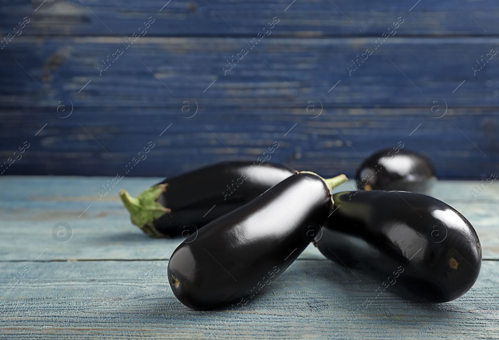 Photo of Tasty raw ripe eggplants on wooden table