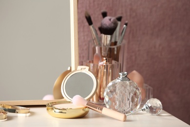 Photo of Different makeup products and accessories on dressing table