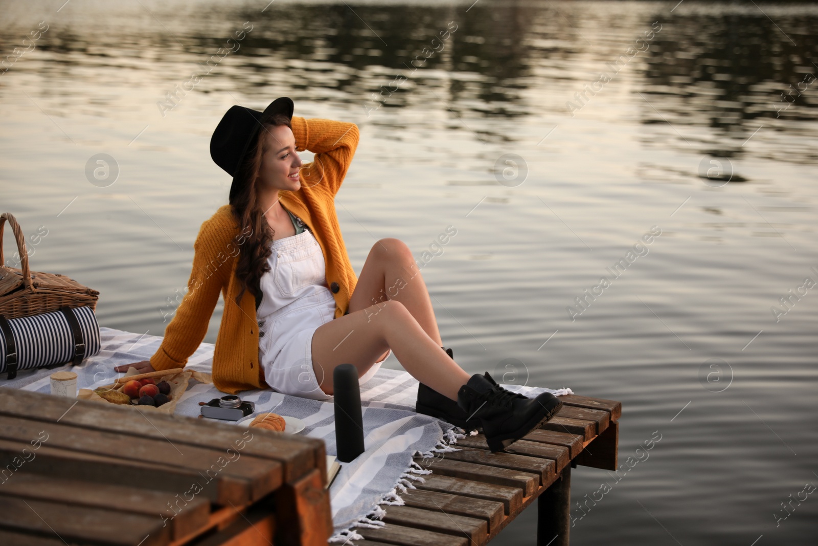 Photo of Young woman spending time on pier at picnic