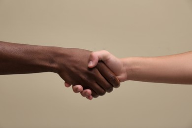 Photo of Men shaking hands on beige background, closeup