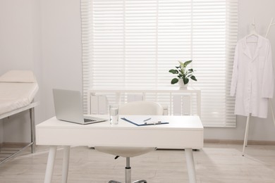 Photo of Modern medical office interior with doctor's workplace