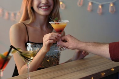 Young woman taking martini cocktail from barman at party, closeup