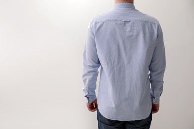 Photo of Man wearing rumpled shirt on white background, back view