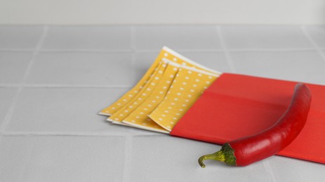 Pepper plasters and chili on white tiled table, closeup. Space for text