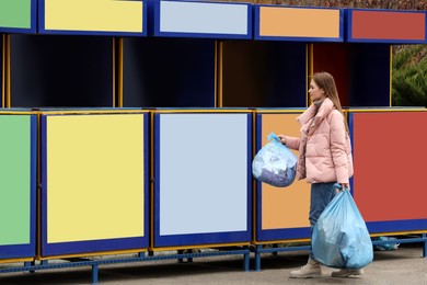 Woman throwing garbage at recycling point outdoors