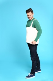 Full length portrait of young man with eco bag on blue background