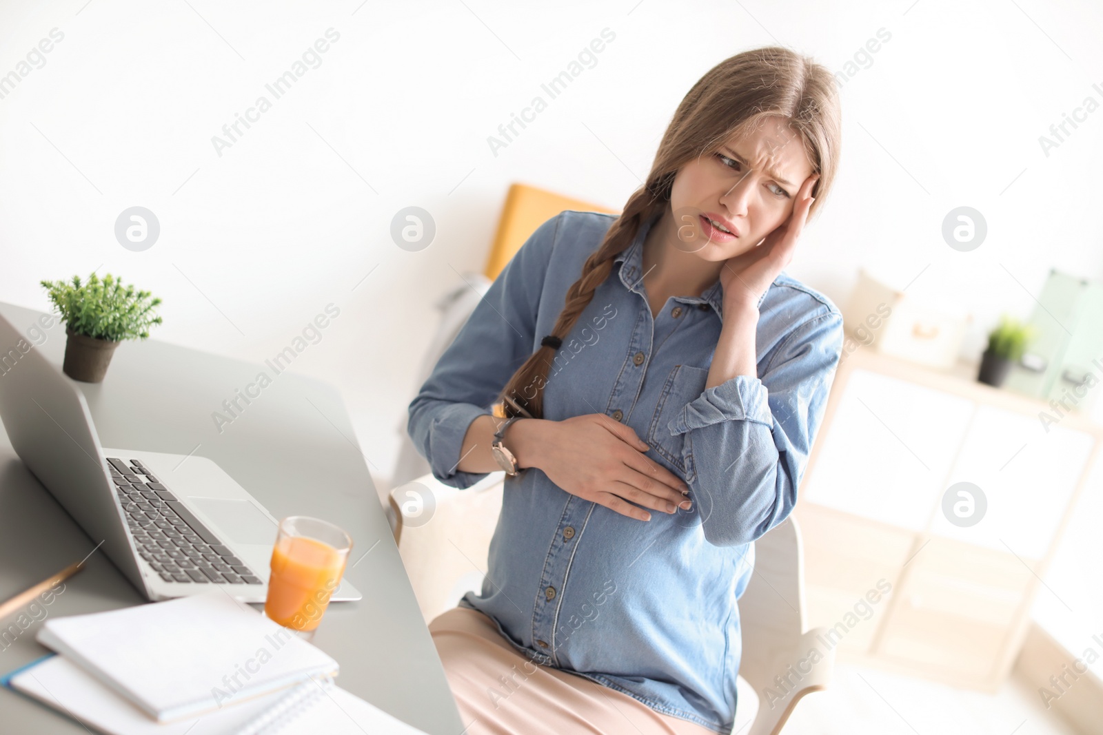 Photo of Pregnant woman suffering from headache at workplace