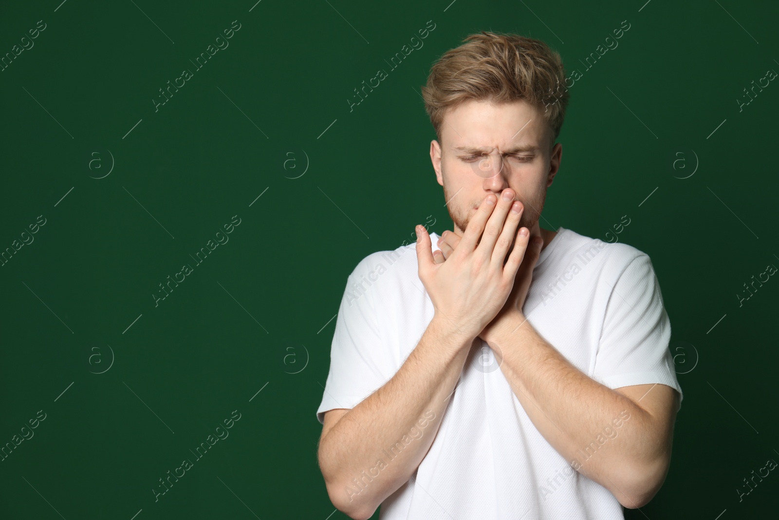 Photo of Handsome young man coughing against color background. Space for text