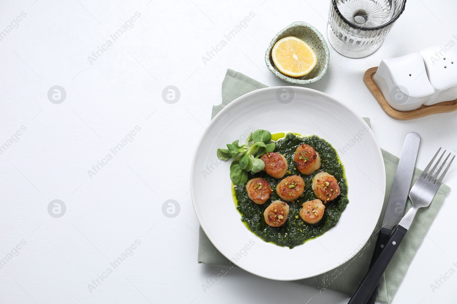 Photo of Delicious fried scallops in bowl served on white table, flat lay. Space for text