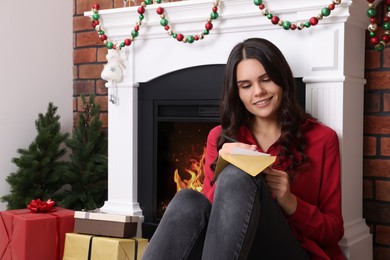 Young woman writing message in greeting card indoors