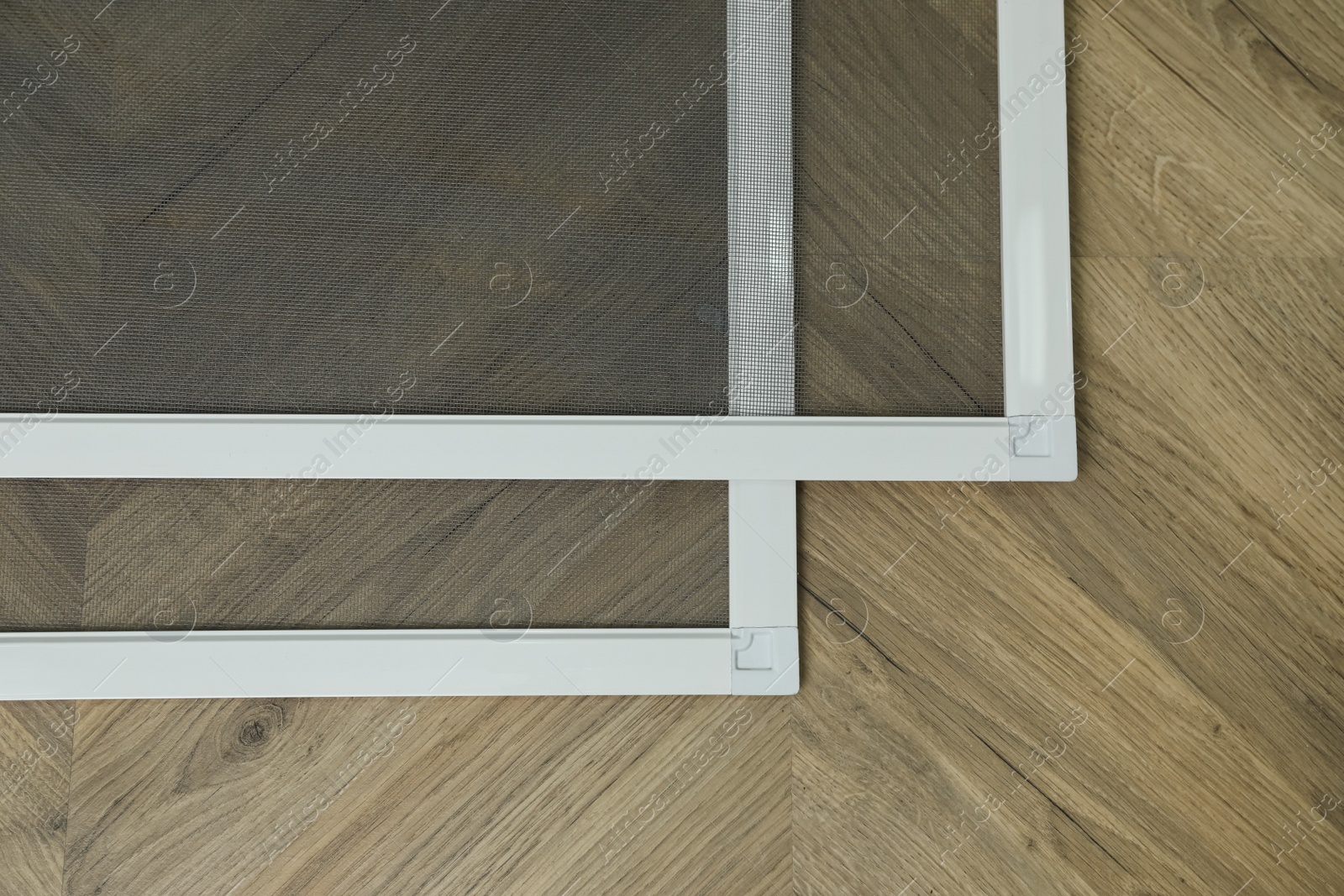 Photo of New window screens on wooden floor, flat lay