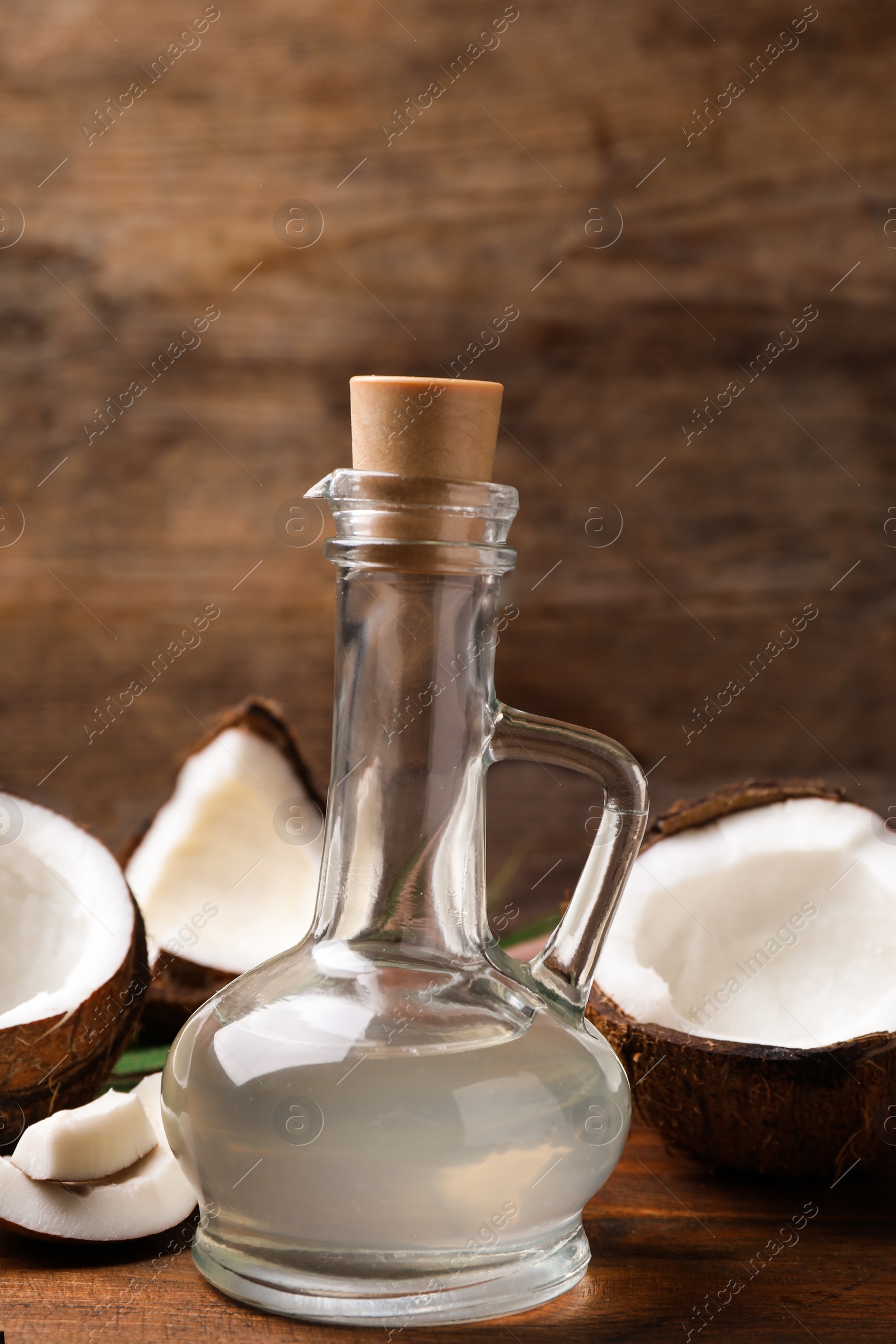 Photo of Coconut oil in glass jug on wooden table