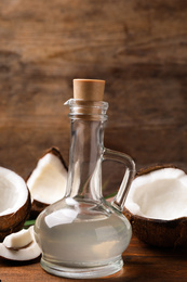 Photo of Coconut oil in glass jug on wooden table