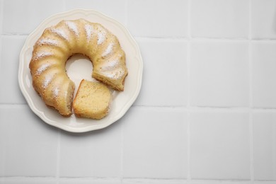 Delicious freshly baked sponge cake on white tiled table, top view. Space for text