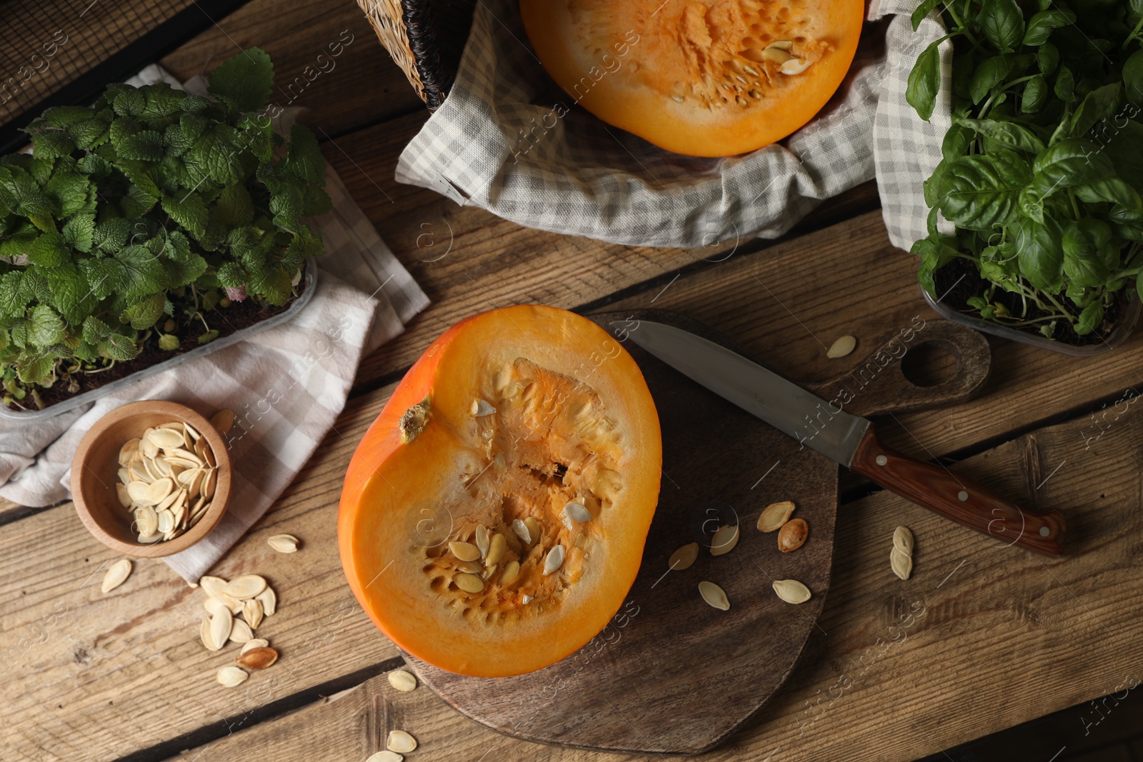 Photo of Cut fresh ripe pumpkin on wooden table, flat lay