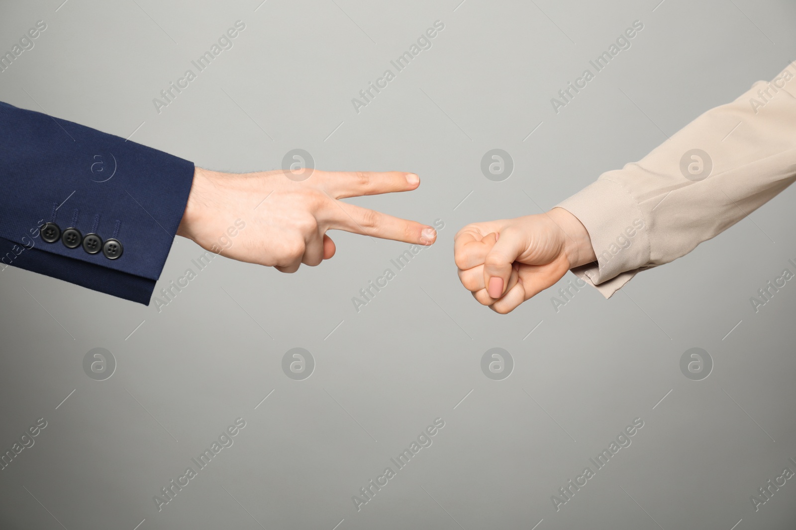 Photo of People playing rock, paper and scissors on grey background, closeup