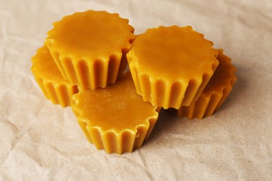 Photo of Natural beeswax cake blocks on parchment paper, closeup
