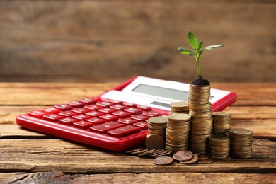 Photo of Stacks of coins with green sprout and calculator on wooden table, space for text. Investment concept