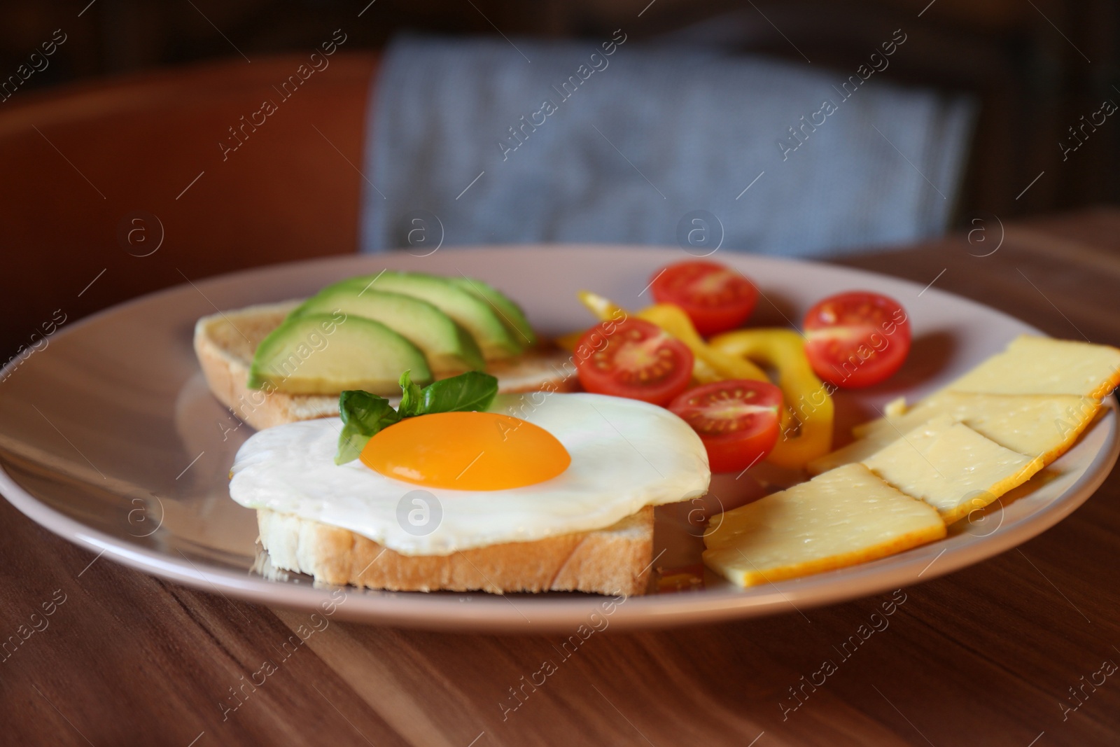 Photo of Tasty toasts with fried egg, avocado, cheese and vegetables on wooden table, closeup