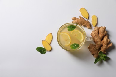 Delicious ginger tea, lemon and mint on light grey background, flat lay. Space for text