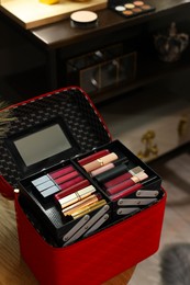 Beautician case with cosmetic products on table in makeup room