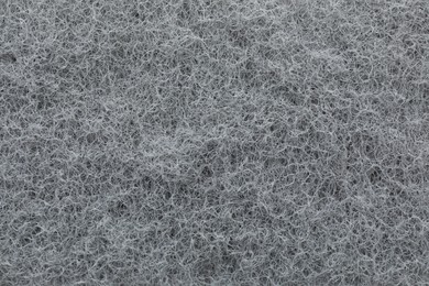 Grey abrasive cleaning sponge as background, top view