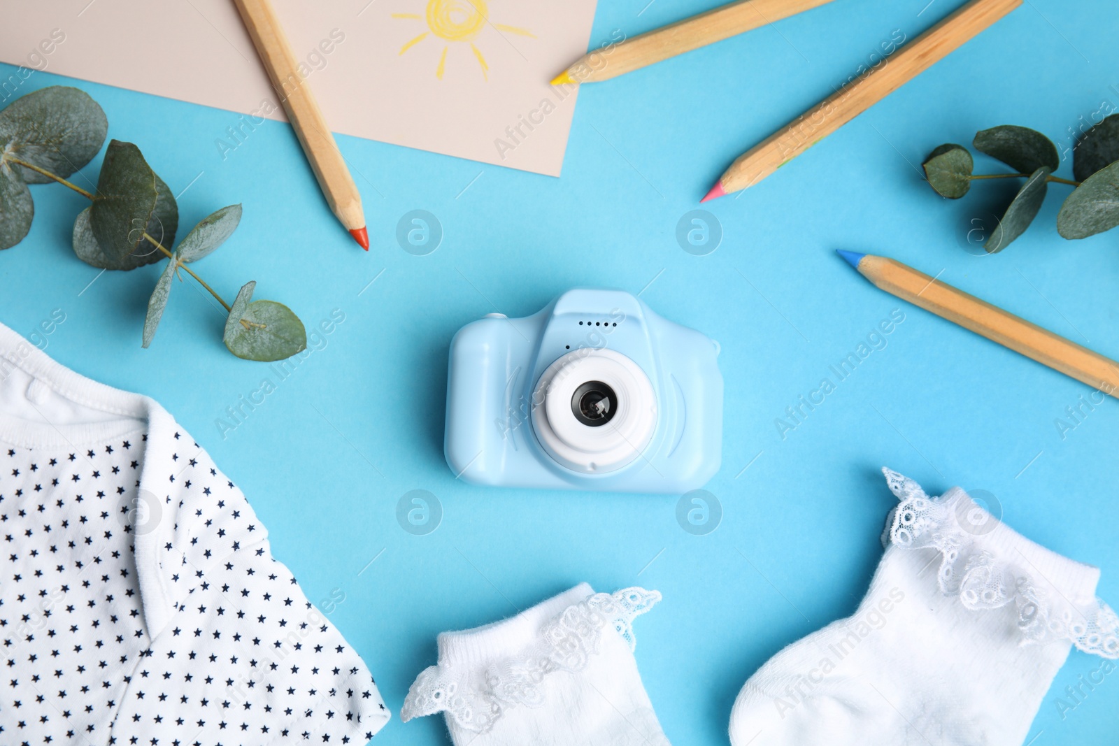 Photo of Flat lay composition with toy camera on light blue background. Future photographer