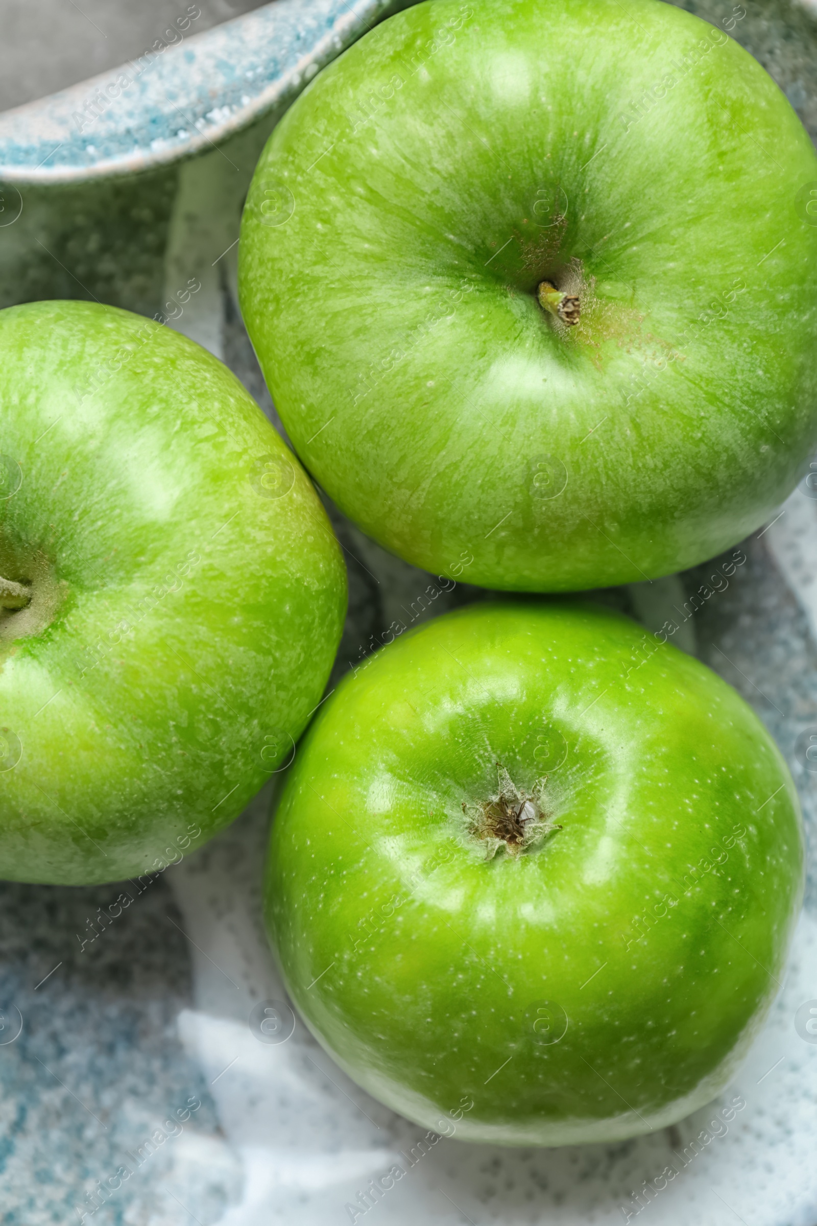 Photo of Fresh green apples on plate, top view