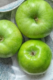 Photo of Fresh green apples on plate, top view