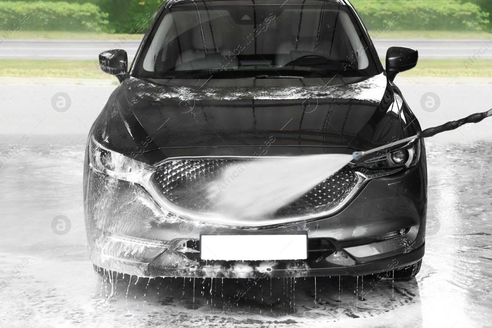 Photo of Washing auto with high pressure water jet at outdoor car wash