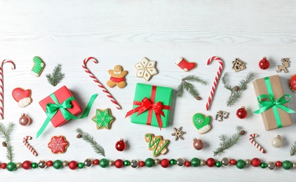 Photo of Flat lay composition with Christmas gift boxes on white wooden background