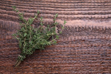 Bunch of fresh thyme on wooden table, top view. Space for text