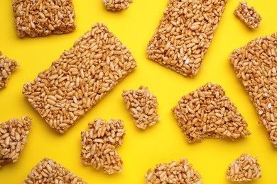 Puffed rice bars (kozinaki) on yellow background, flat lay