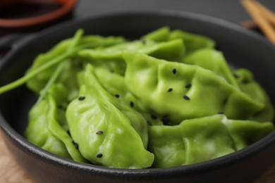 Photo of Delicious green dumplings (gyozas) on wooden table, closeup