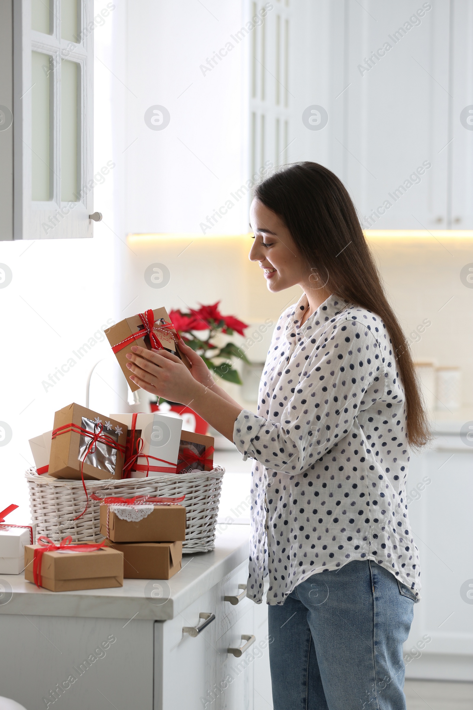 Photo of Woman with Christmas gifts at home. Advent calendar in basket