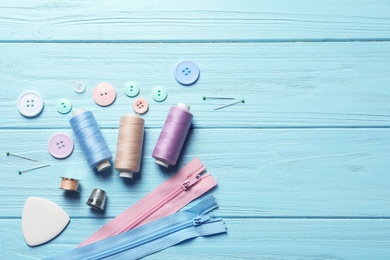 Set of tailoring accessories on wooden background, top view