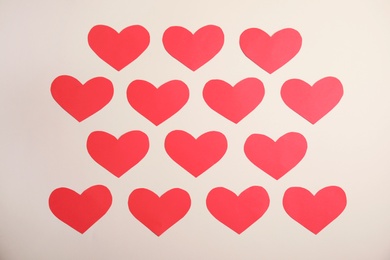 Small paper hearts on color background, top view