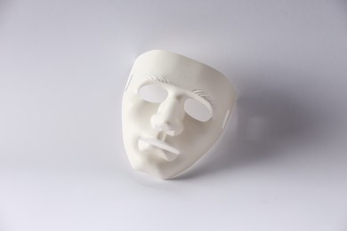 Photo of Plastic face mask on white background. Theatrical performance