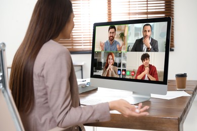 Image of Woman having video chat with coworkers at office