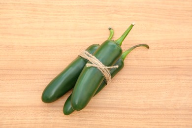 Fresh ripe green jalapeno peppers on wooden table, top view