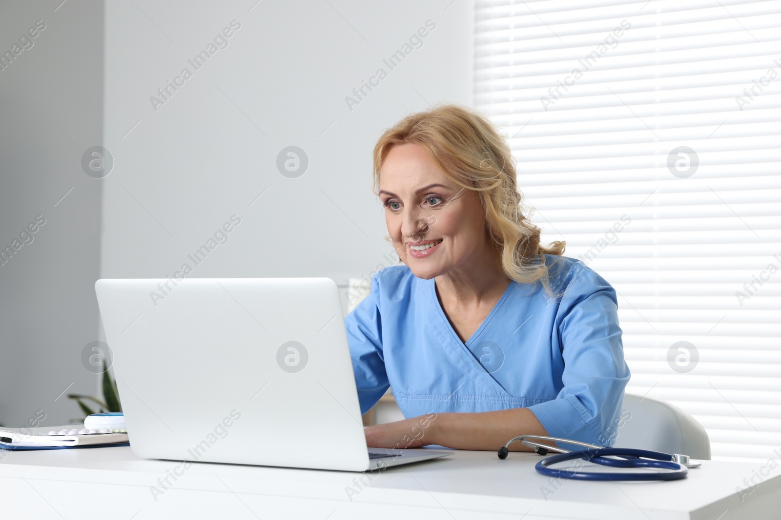 Photo of Doctor with laptop consulting patient in clinic. Online medicine concept