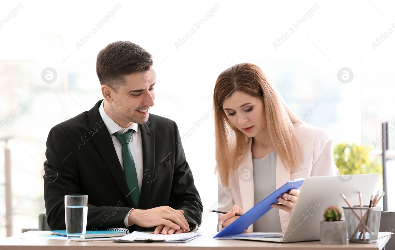 Photo of Young consultant working with client in office