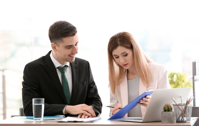 Photo of Young consultant working with client in office