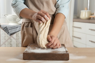 Female baker preparing bread dough at table, closeup