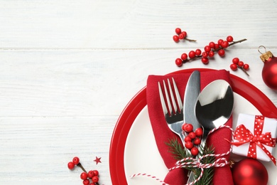 Beautiful Christmas table setting and festive decor on white wooden background, flat lay. Space for text