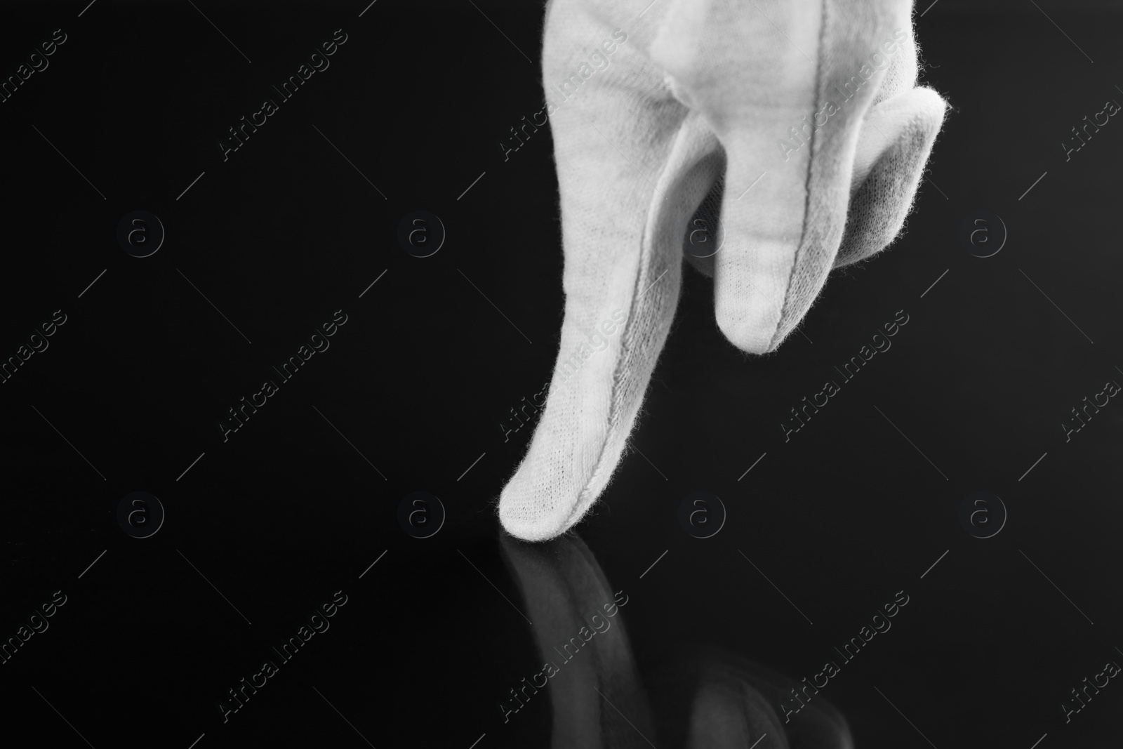 Photo of Woman checking cleanliness of black surface, closeup