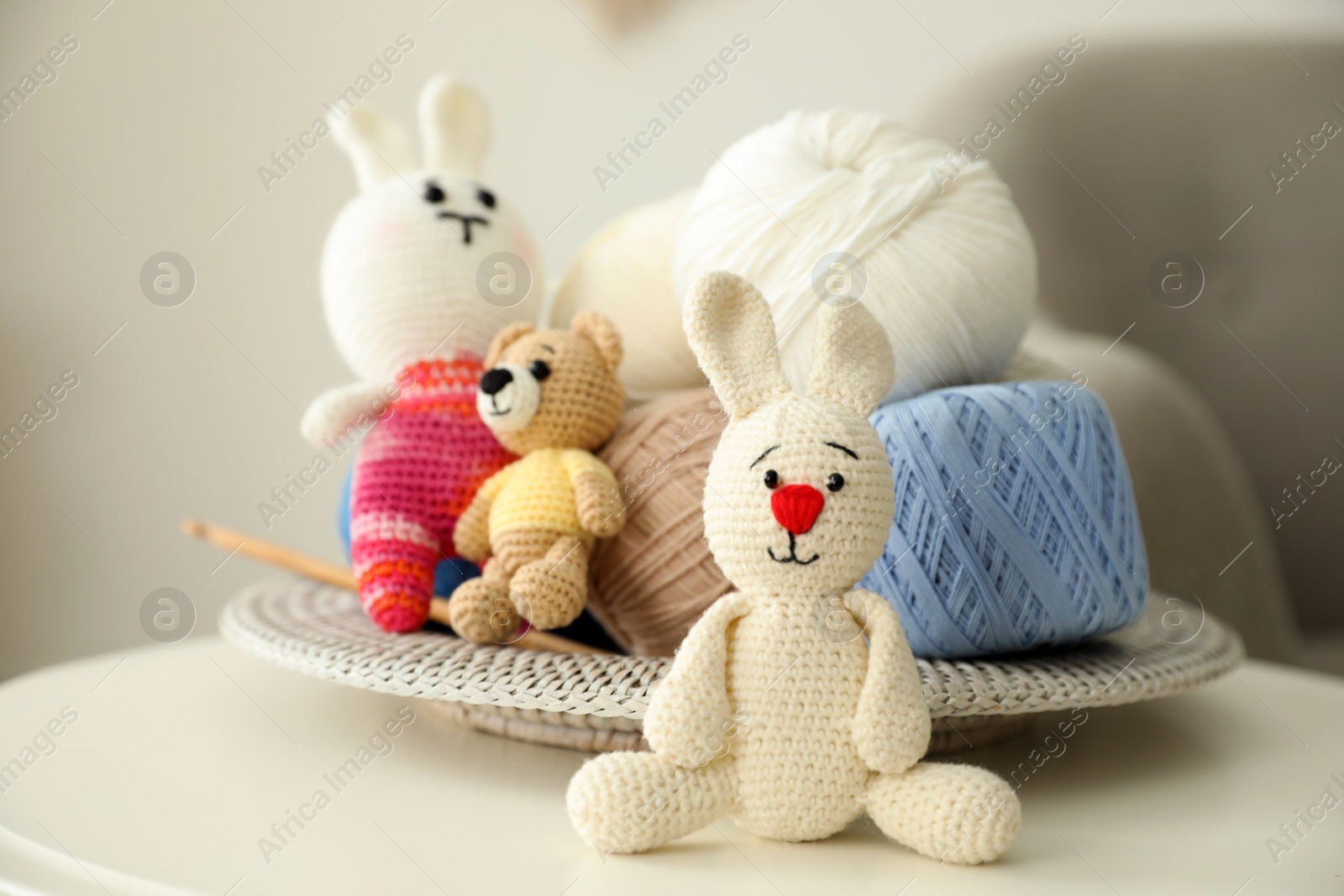 Photo of Crocheted toys and clews on white table. Engaging in hobby