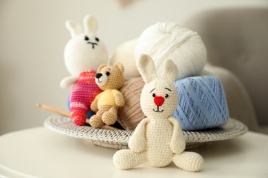 Photo of Crocheted toys and clews on white table. Engaging in hobby