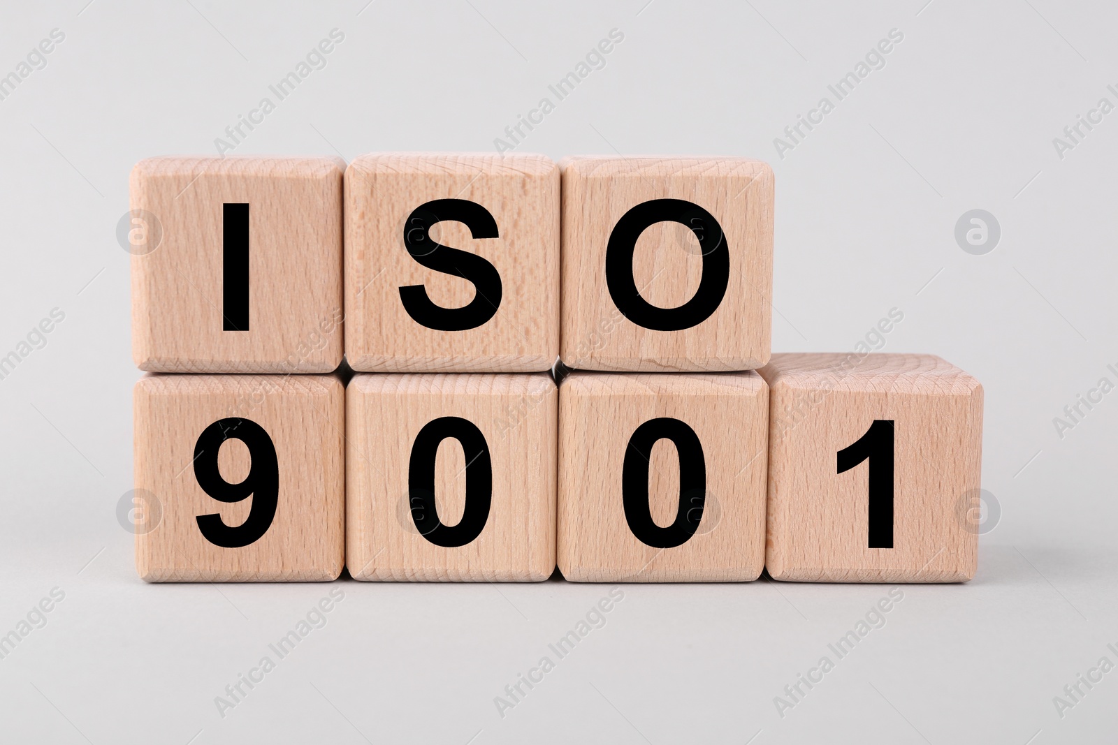 Photo of International Organization for Standardization. Wooden cubes with abbreviation ISO and number 9001 on light grey background