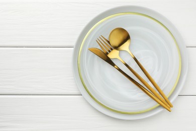 Photo of Stylish setting with cutlery and plate on white wooden table, top view. Space for text